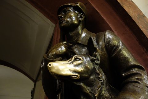 Bronze sculpture of a dog with a shiny nose at Ploshchad Revolutsii metro station.