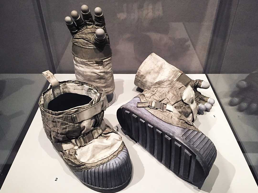 Photography of space museum exhibition showing Apollo missions space boots and gloves.