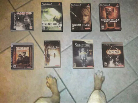 An overhead photo of some furry creature's game collection, which includes 8 Silent Hill games from various platforms such as Playstation and Wii. The creature's dog like legs are visible in the photo thanks to the top-down perspective and add an eerie atmosphere to the photo. Wow.